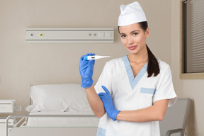 Nurse holding an electric thermometer