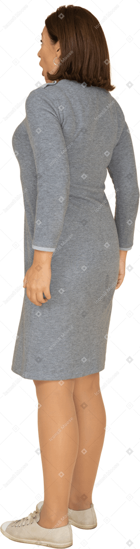Vista laterale di una donna impressionata in abito grigio