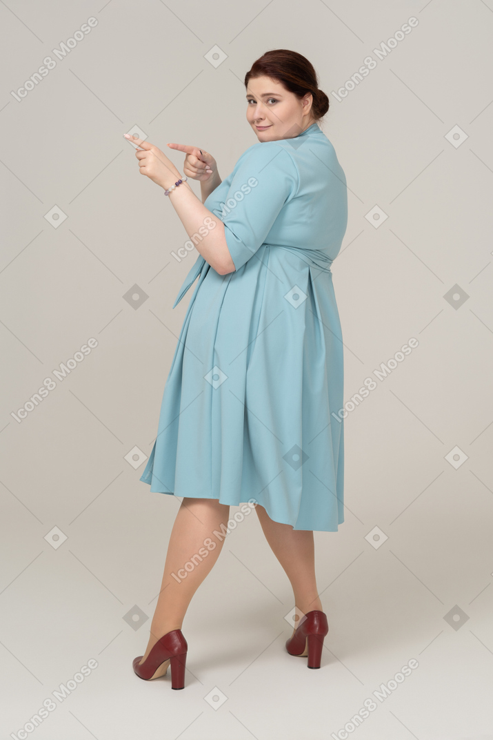 一个穿着蓝色连衣裙跳舞的女人的侧视图