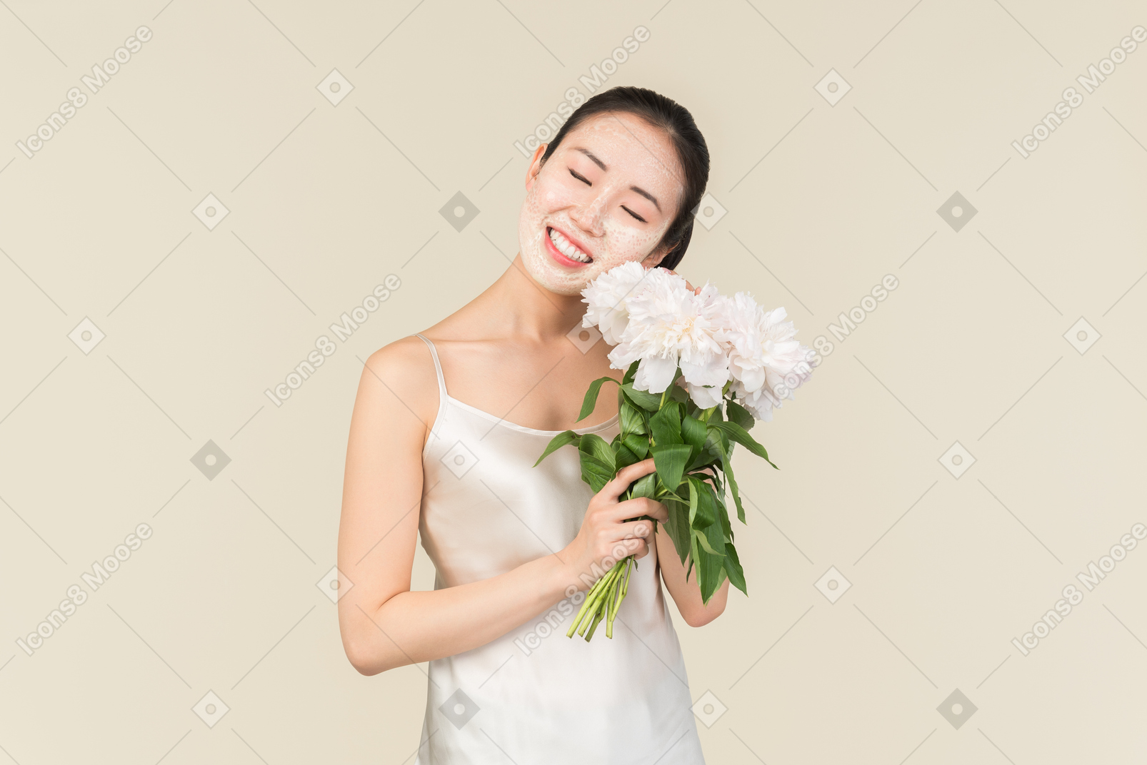 有面部面具的梦想的年轻亚裔妇女在拿着花