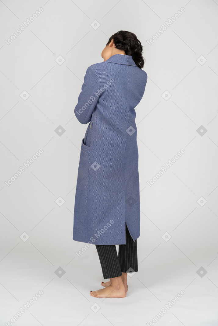 서 있는 코트를 입은 여성의 뒷모습