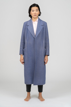 Skeptical woman in blue coat with eyebrow raised