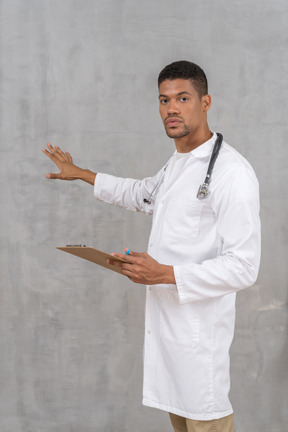 Male doctor holding clipboard and explaining something