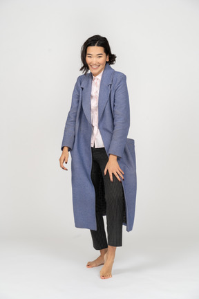 Young woman in coat smiling and looking at camera