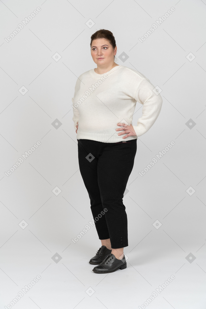 Donna grassoccia in abiti casual in piedi con le mani sui fianchi