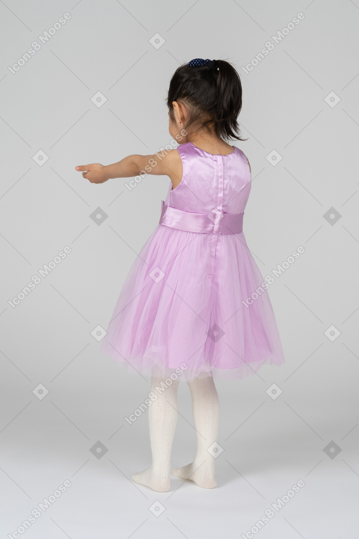 Back view of a little girl reaching out her arms