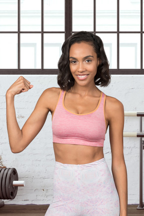 A woman flexing her muscles in a gym