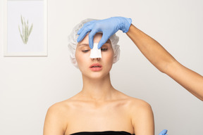 Nurse putting gauze on patient's nose