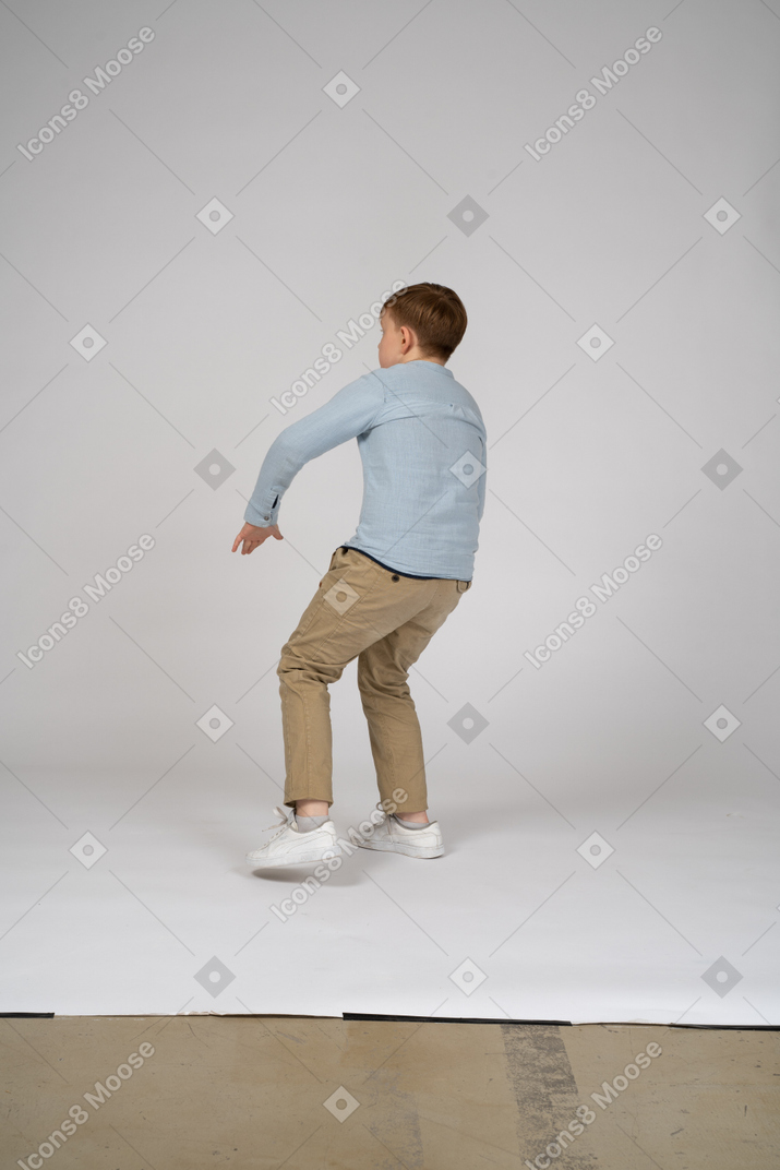 Vista traseira de um adolescente pulando para trás