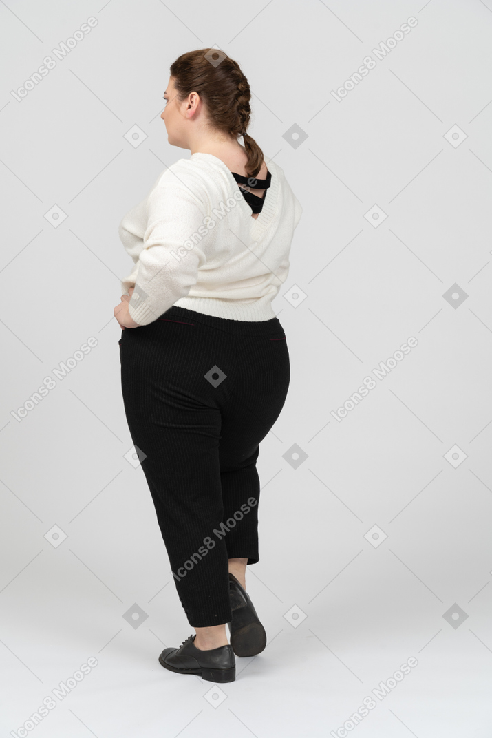 穿着白色毛衣的胖女人双手叉腰摆姿势