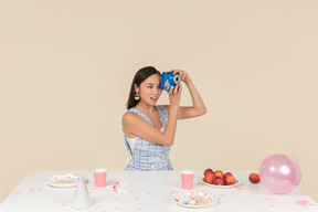 Junge asiatische frau, die geburtstag feiert und ein foto macht