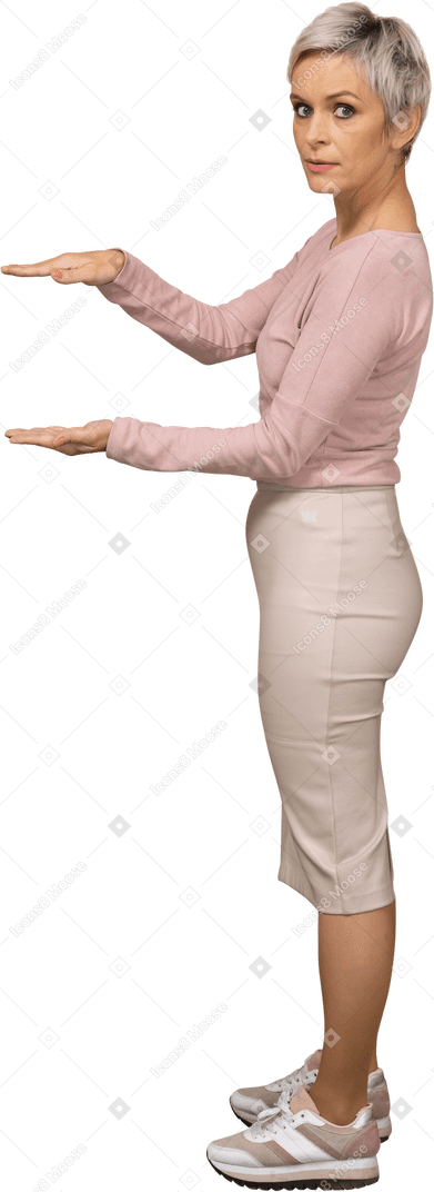 Vista lateral de una mujer en ropa casual que muestra el tamaño de algo