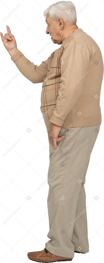 Vista lateral de un anciano con ropa informal que muestra un gesto de roca