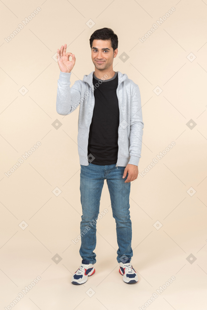 Young caucasian man showing an ok sign