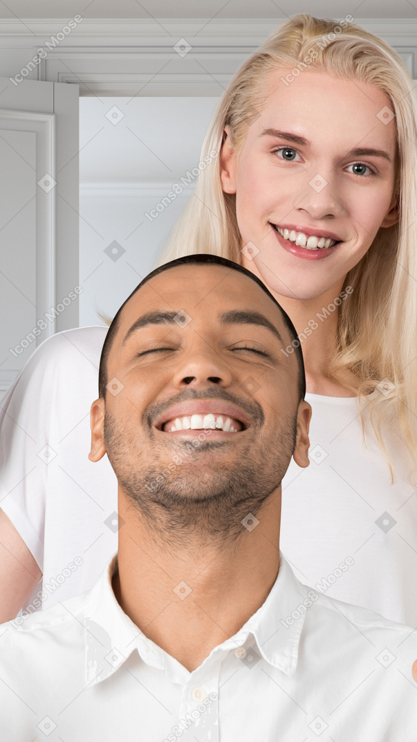 Blond person standing behind a smiling man