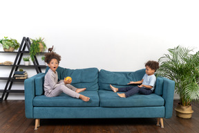 Good looking boy and girl play on the sofa