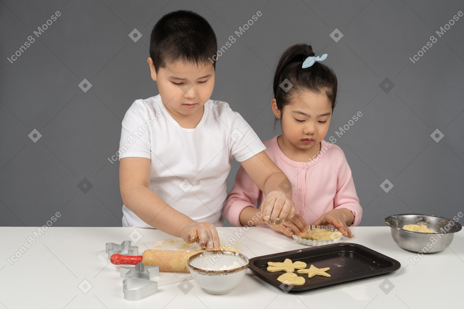 Boy teaching his sister to bake cookies