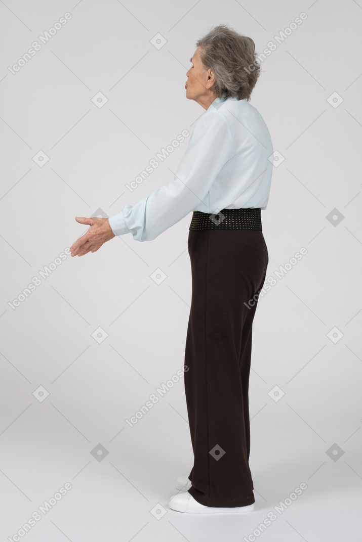 Three-quarter back view of an old woman gesturing questioningly