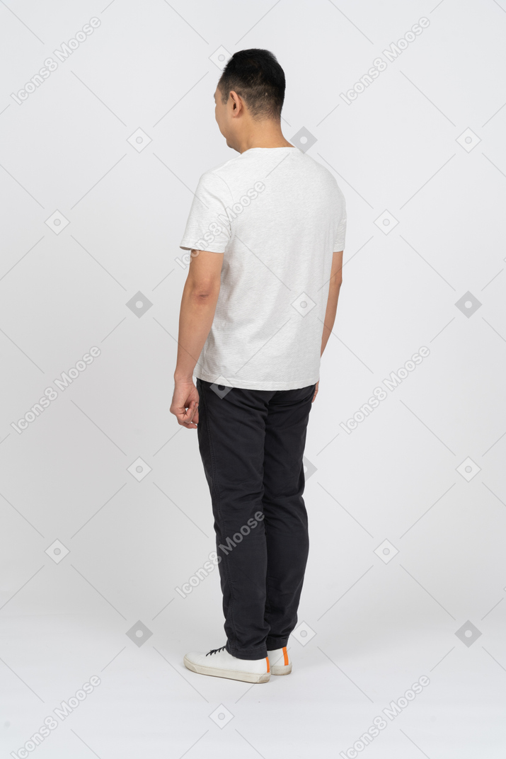 Мужчина в повседневной одежде стоит спиной к камере