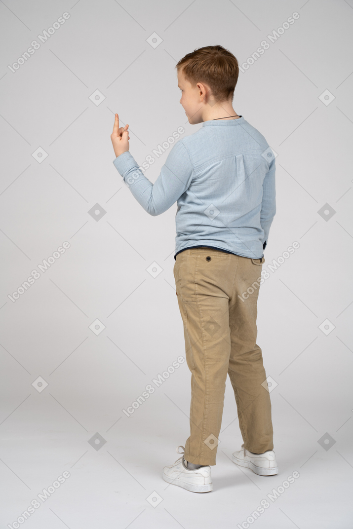 Vista traseira de um menino fazendo gesto de rock