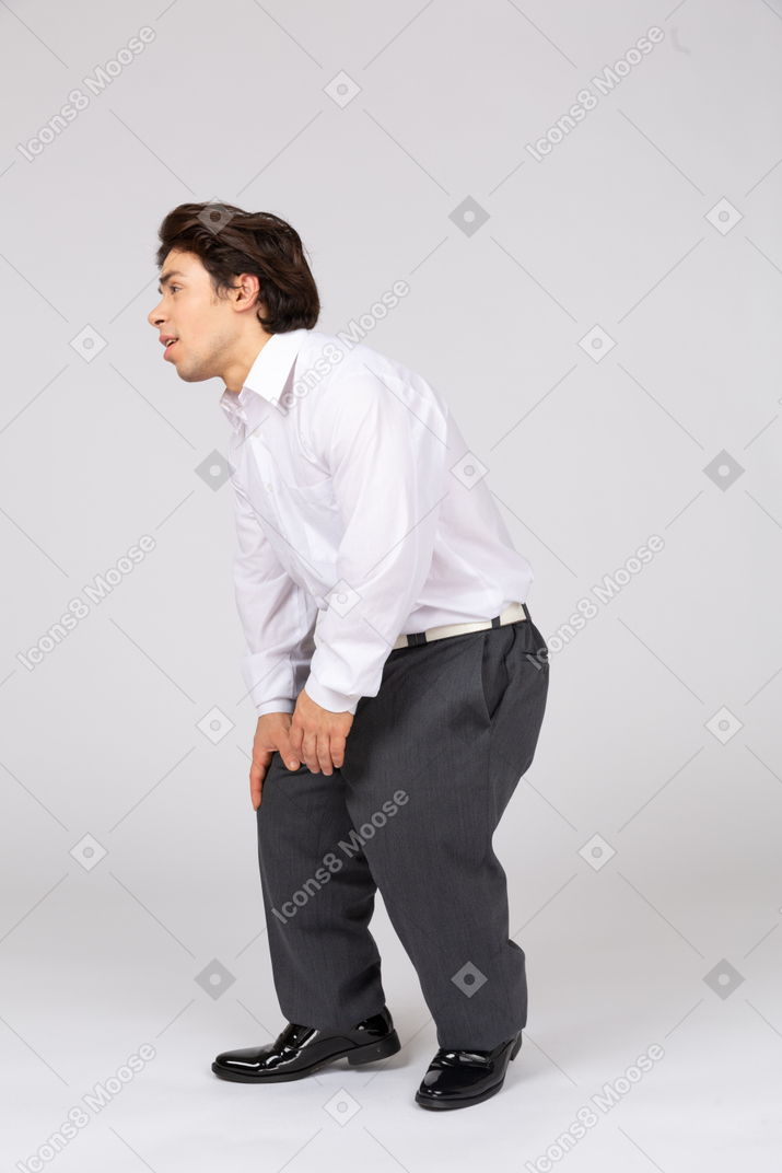 Side view of man groaning with pain in legs