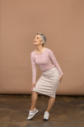 Vista frontal de uma mulher com roupas casuais tocando seu joelho