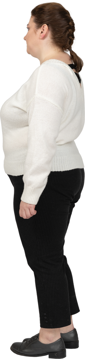 Confident plus size woman in white sweater standing in profile