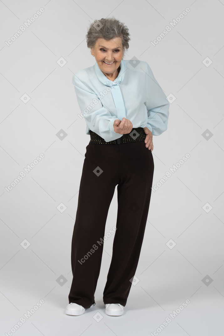 Front view of an old woman stretching out hand with a smile