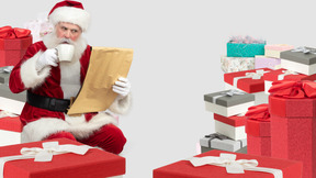 Санта-клаус пьет кофе и читает подарочные списки