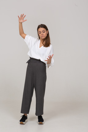Vista frontal de uma jovem com roupa de escritório, mostrando o tamanho de algo
