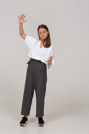 Front view of a young lady in office clothing showing a size of something