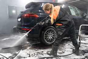 Young woman washing car