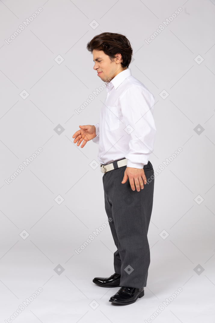Unwilling man in business casual clothes giving hand for handshake