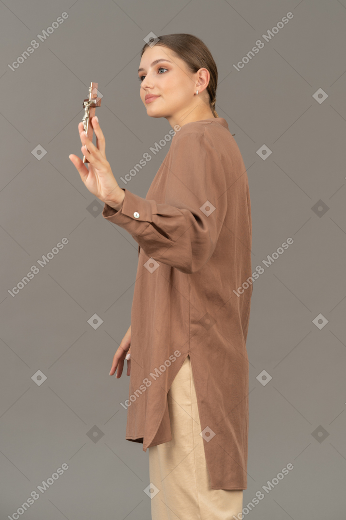 Side view of a christian woman showing off a cross