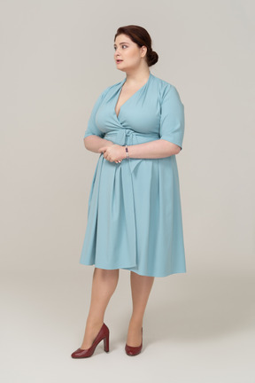 Вид спереди женщины в голубом платье, смотрящей в камеру