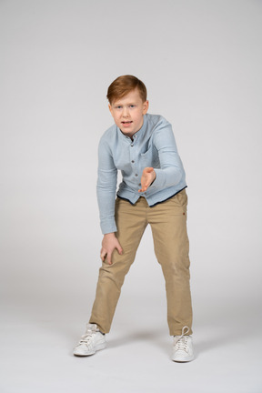 A young boy in a blue shirt and khaki pants
