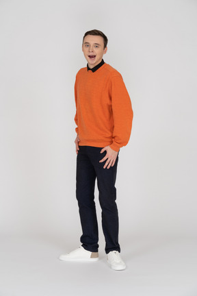 Jeune homme en sweat-shirt orange debout