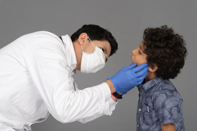 Médico examinando dentes de menino