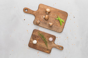 Some mushrooms, greens and garlic on wooden cutting boards