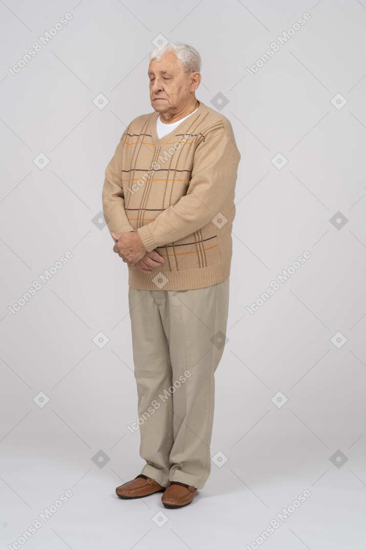Vista frontale di un vecchio in abiti casual in piedi con le mani incrociate