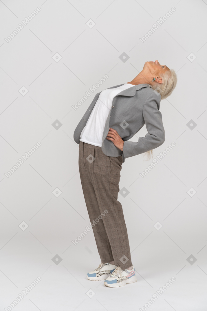 Side view of an old lady in suit stretching