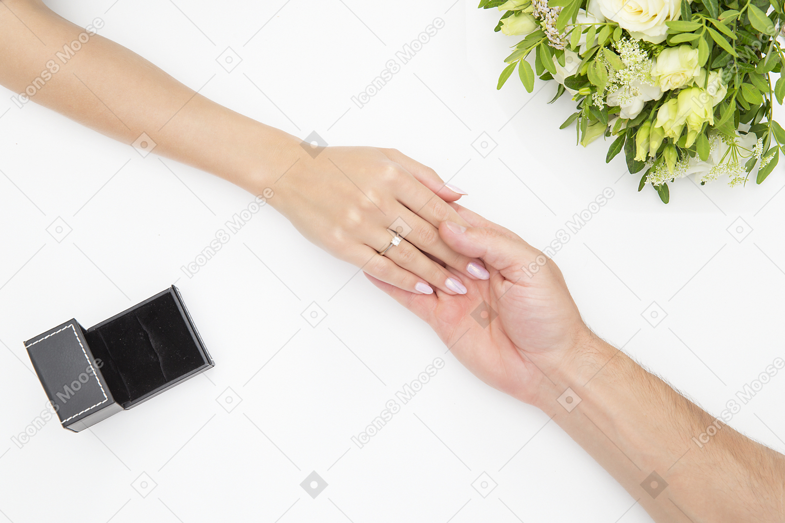 Male hand holding female hand with ring on it