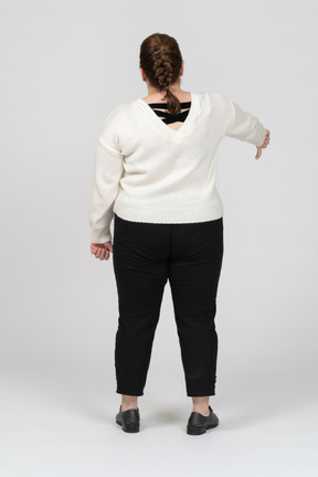 Mujer de talla grande en suéter blanco mostrando el pulgar hacia abajo