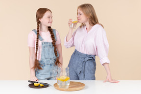 Two young girls drinking lemon water