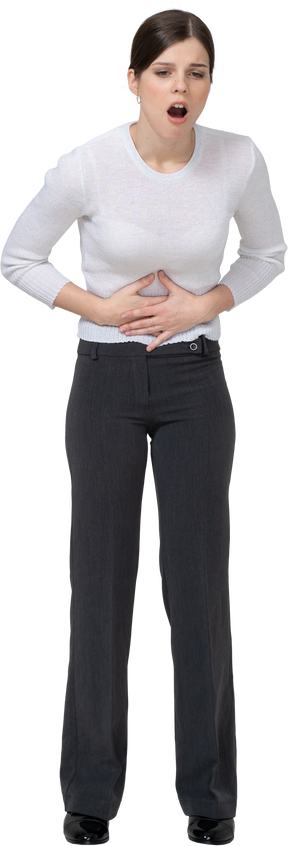 Front view of a young woman in office clothing touching stomach