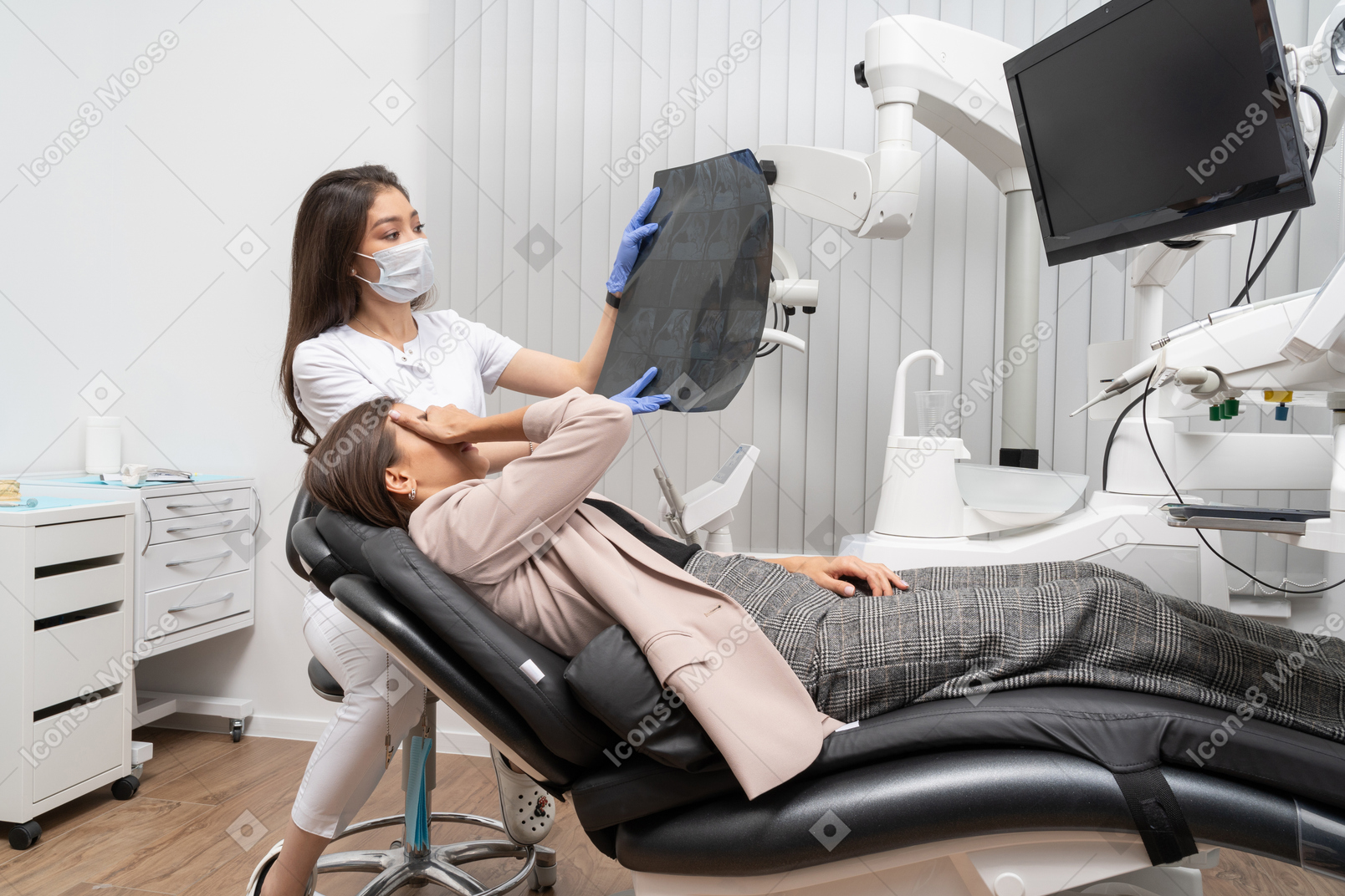 Comprimento total de uma médica mostrando imagem de raio-x e uma paciente assustada fechando os olhos com a mão