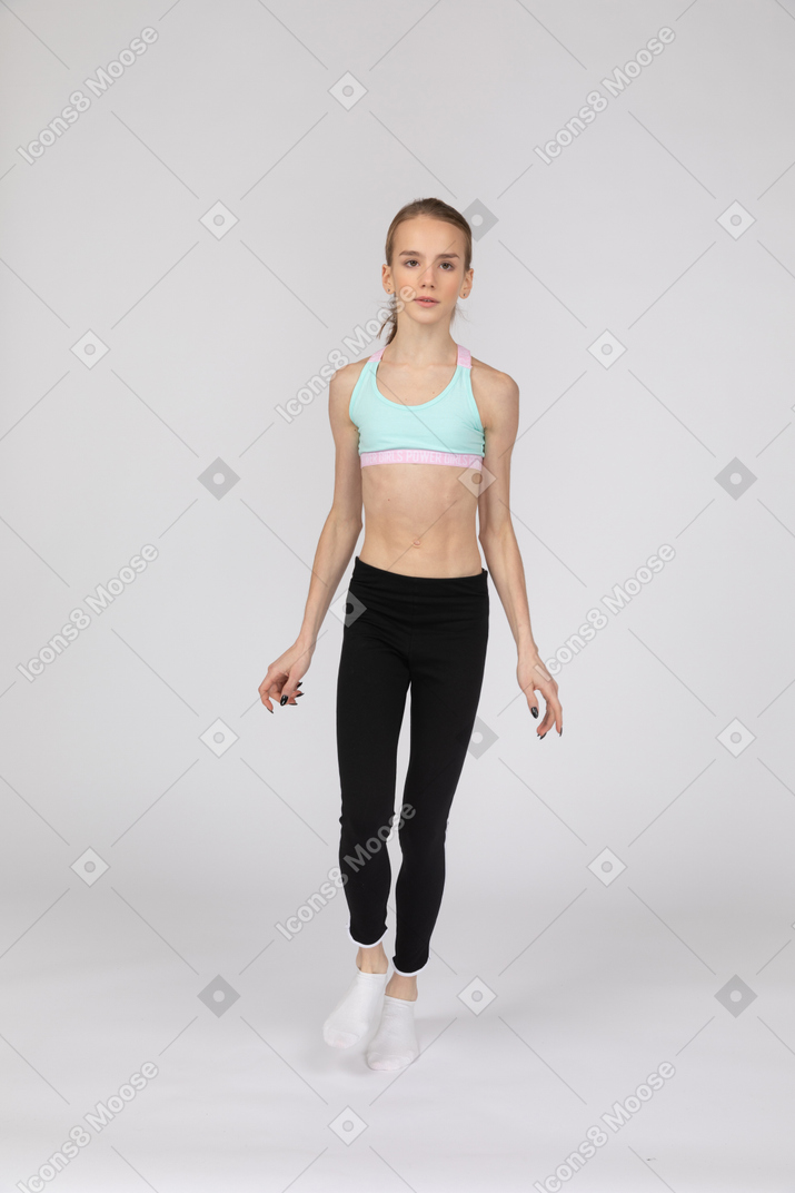 Front view of a teen girl in sportswear stepping forward