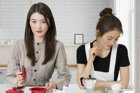 Two women sitting at a table with cups and saucers