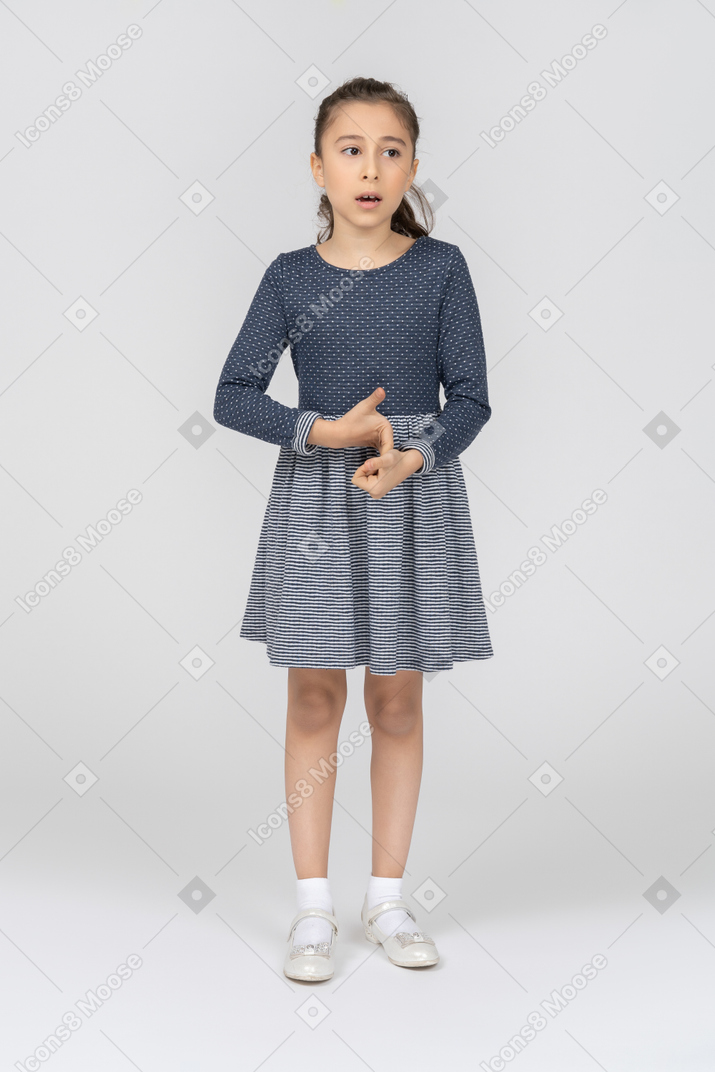 Vista frontal de una niña agarrando las manos nerviosamente