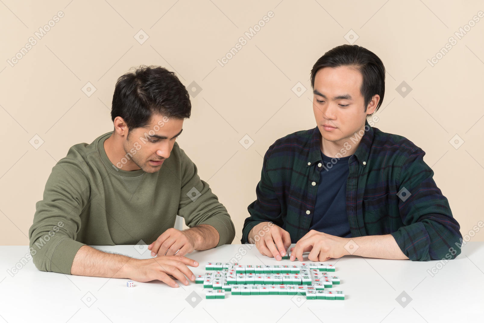 Young interracial friends sitting at the table and playing scramble game